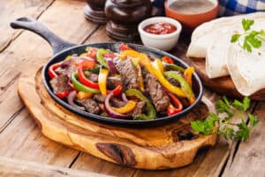 fajitas on a skillet with peppers and onions 