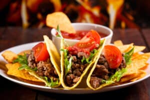 plate of tacos with lettuce and tomatoes 